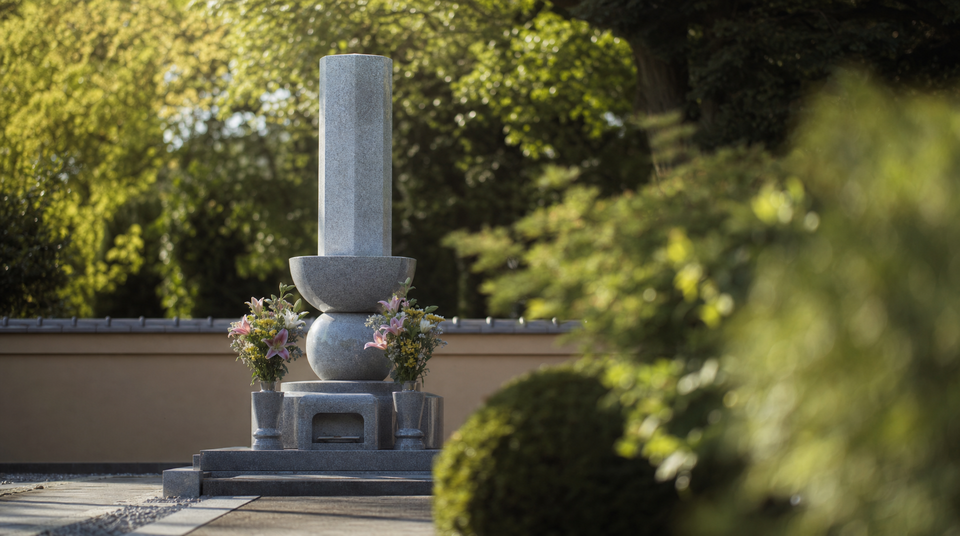 緑に囲まれた永代供養墓の合祀塔に花が供えられた様子